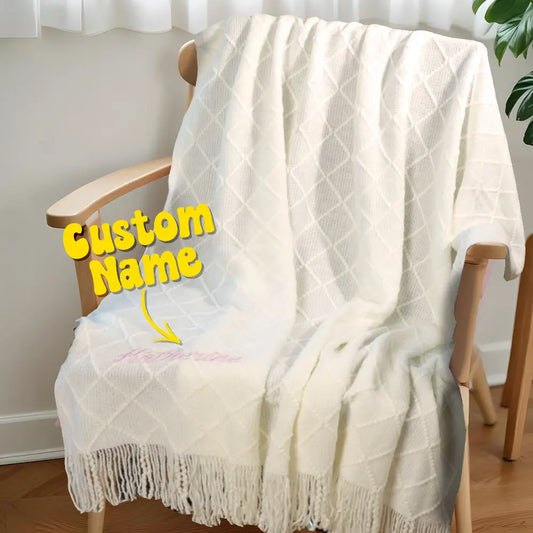 Front view of a soft cotton personalised tassel blanket for kids, featuring an embroidered name and decorative tassels.