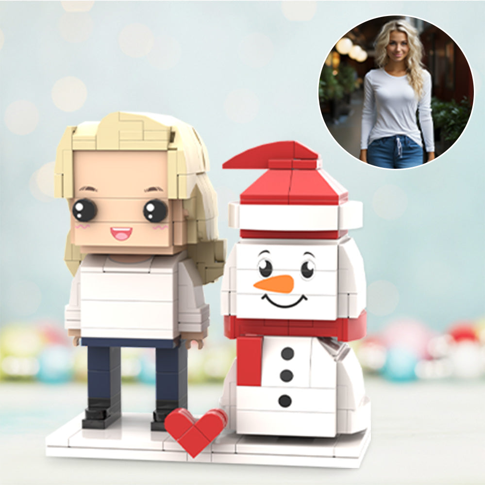 Front view of a personalised Christmas brick figure beside a fixed snowman on a festive base — small particle block toy personalised from your photo, hand-assembled ABS gift