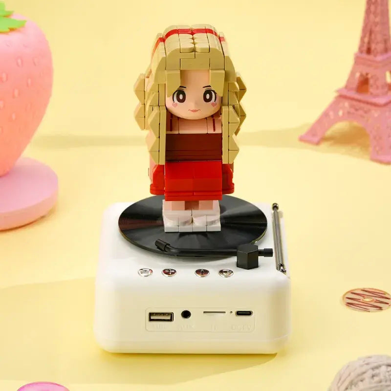 Scale comparison showing a customisable one-person brick figure on a Bluetooth speaker base held in the hand to illustrate size of personalised brick figure