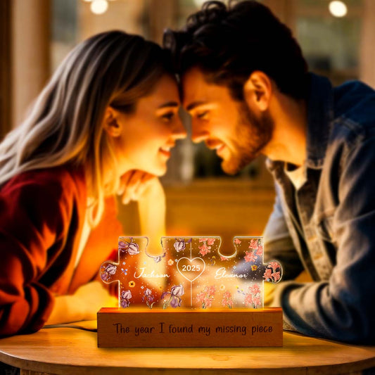 Personalised Couple Puzzle Night Light showing intertwined names and birth flowers laser-etched on gallery-grade acrylic with a sustainable wooden base, warm LED glow — custom name & birth flower LED gift for anniversaries