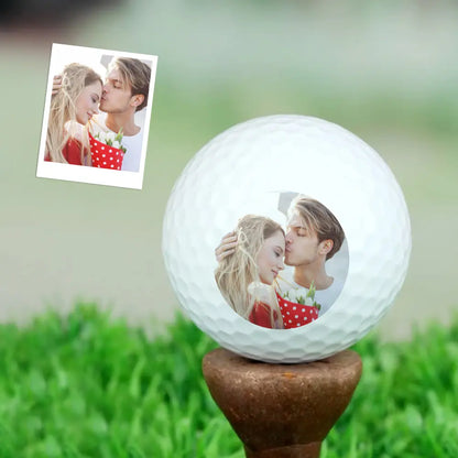 Personalised photo golf ball on tee in grass highlighting aerodynamic dimple pattern and natural play appearance