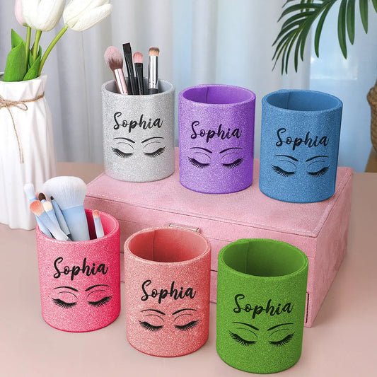 Personalised glitter leather makeup brush holder with custom name on glitter panel, compact leather brush cup filled with brushes on a dressing table — perfect personalised vanity cup and travel brush organiser