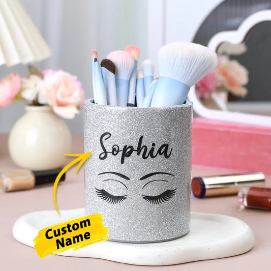 Personalised glitter leather makeup brush holder with custom name on glitter panel, compact leather brush cup filled with brushes on a dressing table — perfect personalised vanity cup and travel brush organiser