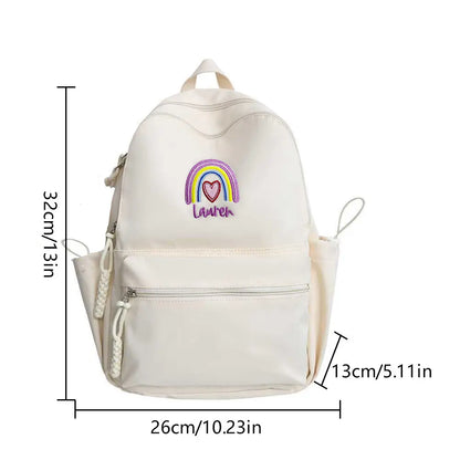 Three-quarter angled view showcasing vibrant rainbow embroidery and roomy main compartment of personalised backpack – great gift for classmates