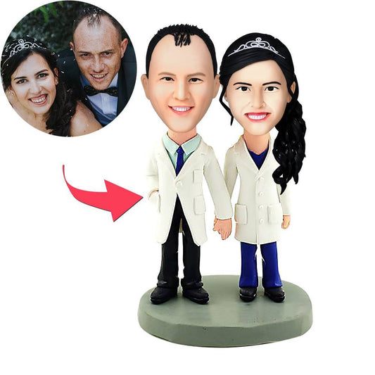 Front view of personalised doctors couple bobblehead polymer clay figurine with customised heads and engraved text on the base — a personalised medical gift and doctor bobblehead ideal for graduation or retirement, a custom couple bobblehead