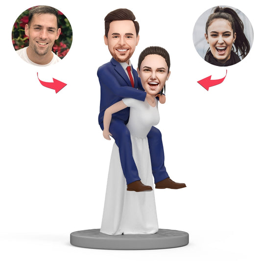 Personalised bride carrying groom polymer clay bobblehead with custom head and engraved base — wedding keepsake