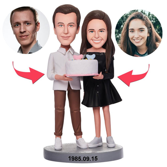 Personalised couple bobblehead holding a birthday cake – handmade polymer clay figures with custom heads from your photos, ideal personalised birthday gift for couples in the UK and Australia