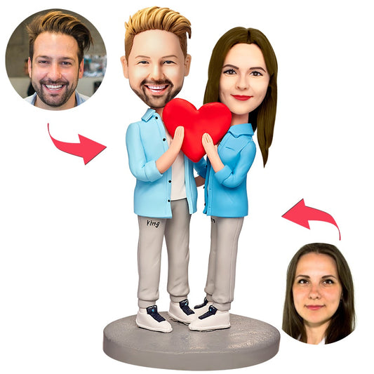 Personalised couple bobbleheads in Love Heart outfits — handcrafted polymer clay figurines with engraved name and date on the base, ideal personalised anniversary or wedding keepsake