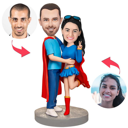 Personalised Superman couples bobbleheads in polymer clay, front view with engraved base showing custom text — personalised superhero anniversary or wedding gift