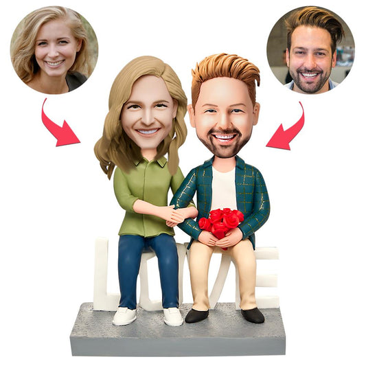 Handcrafted sitting couple personalised Valentine’s Day bobblehead in polymer clay with engraved text on the base — customised heads from your photos, ideal anniversary or engagement keepsake