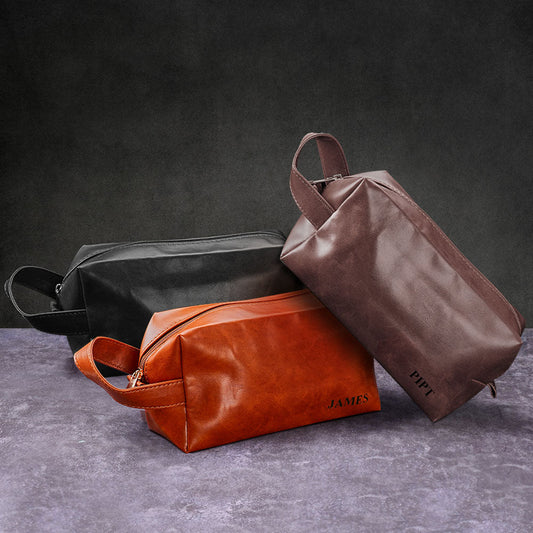 Personalised name engraved men's toiletry travel bag in PU leather — front view showing custom engraving and smooth zip, ideal personalised travel wash bag/dopp kit.