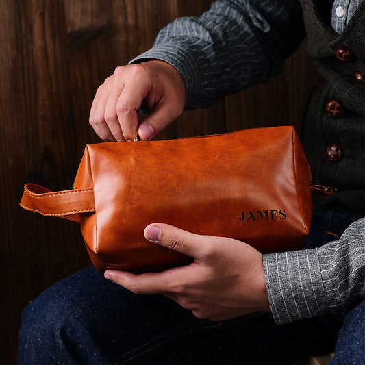 Personalised name engraved men's toiletry travel bag in PU leather — front view showing custom engraving and smooth zip, ideal personalised travel wash bag/dopp kit.