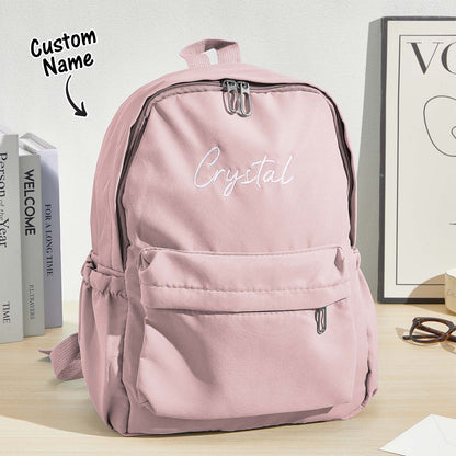 Angled view of canvas personalised backpack showing roomy main compartment and two side pockets, embroidered name child school bag