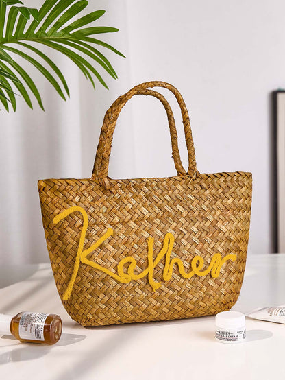 Custom name detail on personalised straw bucket bag showing bespoke lettering for bridesmaids mother and friends gift