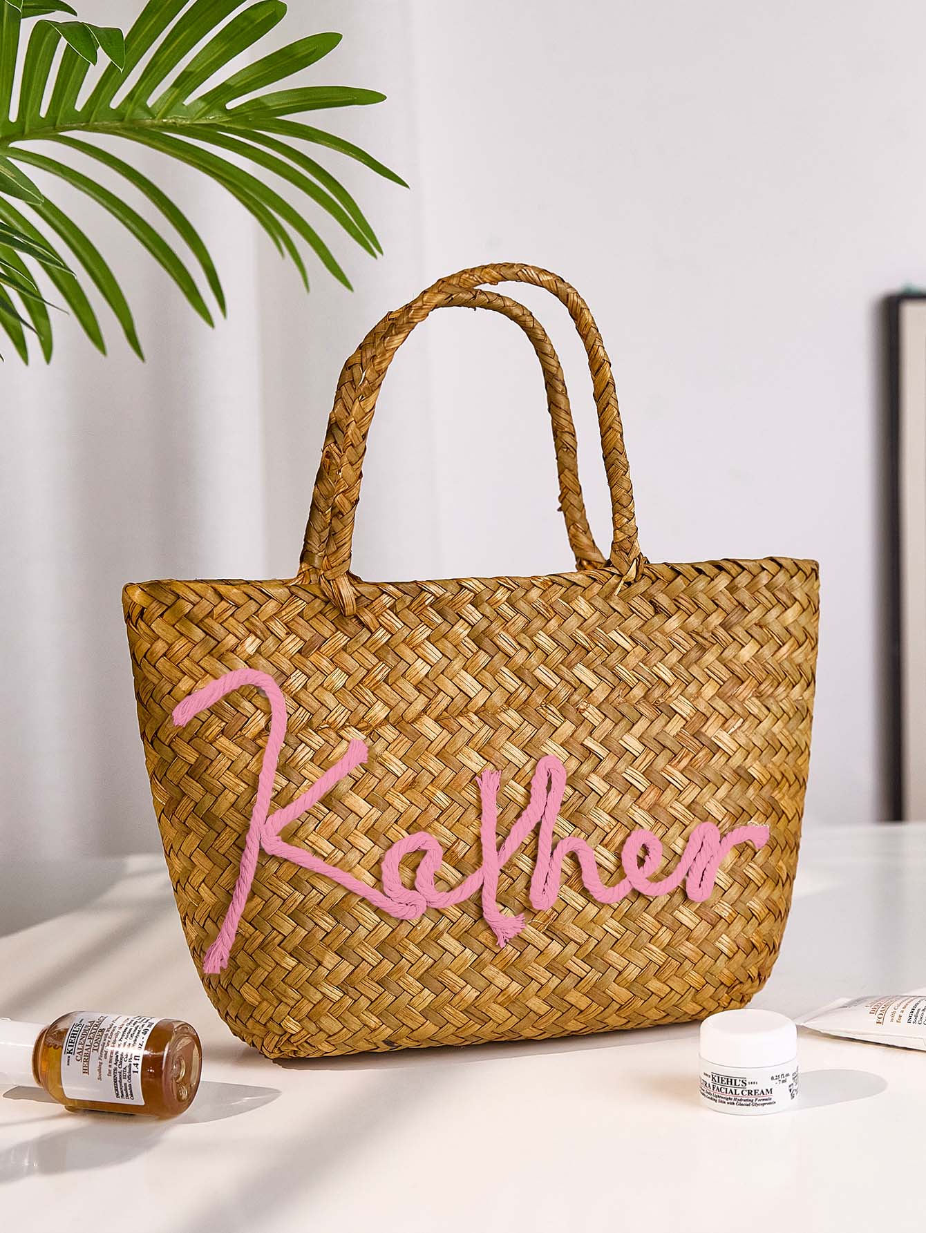 Model holding personalised handmade straw bucket bag for size reference 28cm x 18cm x 6cm, perfect for beach and holiday trips