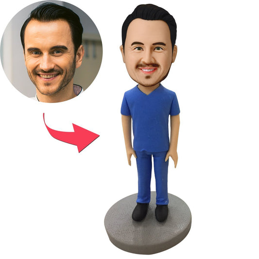 Personalised medical bobblehead — male in blue scrubs, polymer clay figure with a custom head matched to your photos and engraved text on the base