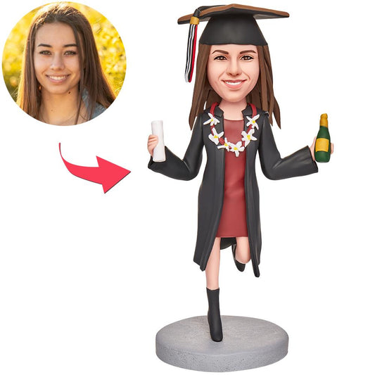 Personalised polymer clay graduation bobblehead of a girl holding a teddy bear and certificate with engraved text on the base – custom graduation gift