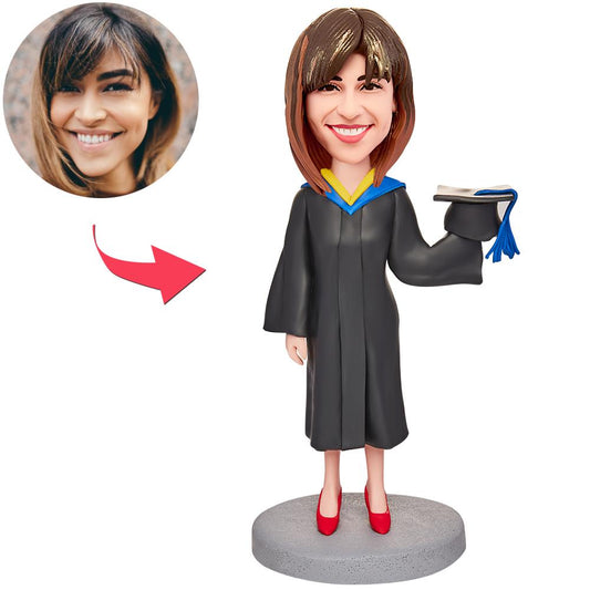 Personalised graduation girl bobblehead with engraved text on base, handcrafted polymer clay keepsake featuring a customised head in cap and gown — ideal graduation gift