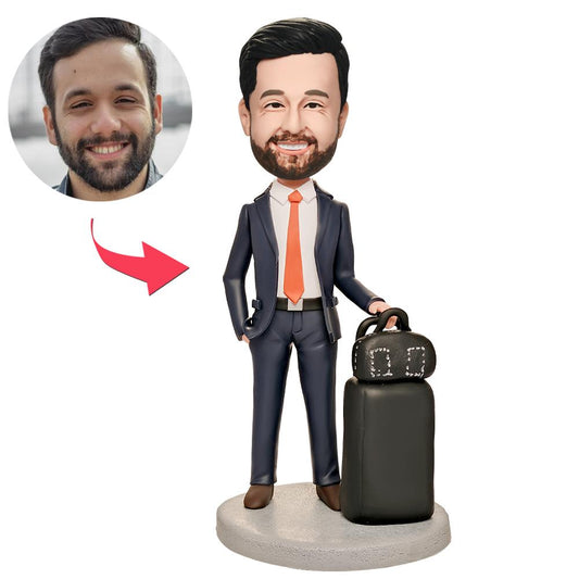 Personalised World Traveller executive bobblehead in a navy suit holding a miniature globe, hand‑modelled polymer clay head personalised from a photo with engraved name plate – travel‑themed personalised desk ornament.