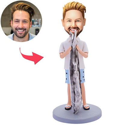 Personalised polymer clay bobblehead of a man holding a large fish, head customised from your photo with engraved base for name or date — custom fisherman figurine gift