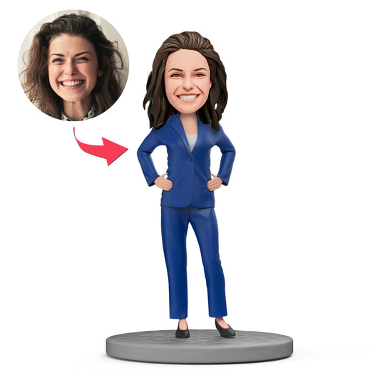 Personalised female boss bobblehead in blue suit with crossed arms — customised head likeness and engraved text on the base, polymer clay executive keepsake