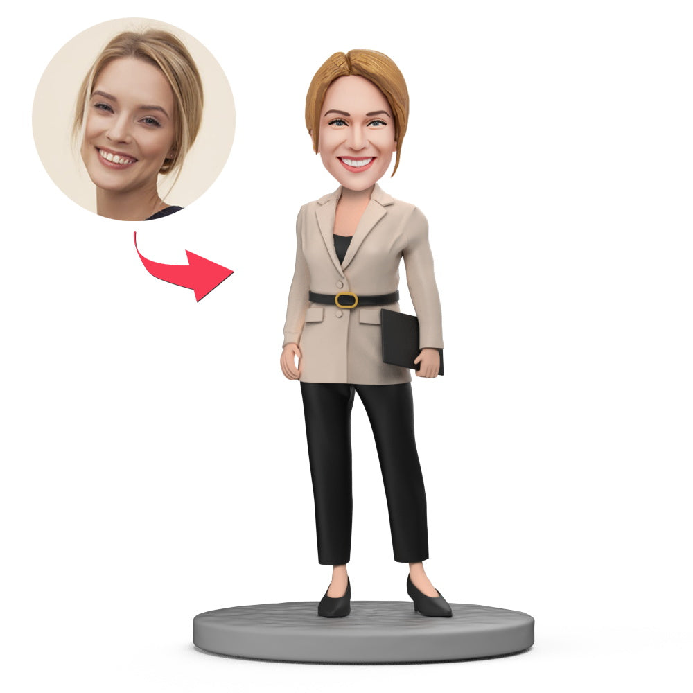 Personalised office lady bobblehead in beige jacket and black trousers, polymer clay figurine with a custom head sculpted from your photo and optional engraved text – ideal personalised gift for UK and Australia