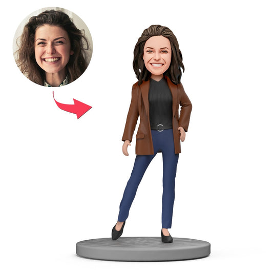 Personalised polymer clay bobblehead of a fashionable lady in a brown coat and black jumper with engraved base — custom bobblehead gift for her.