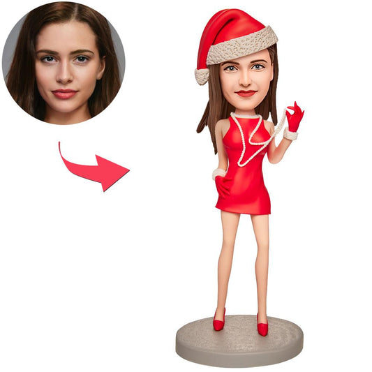 Personalised polymer clay Christmas girl bobblehead wearing a pearl necklace with engraved name on the base, front view, custom head