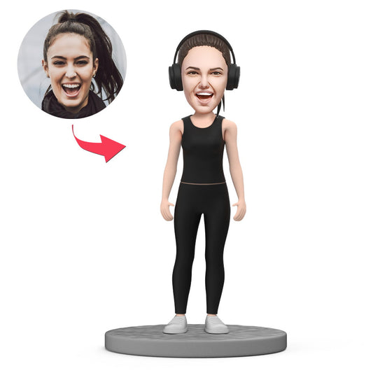 Personalised girl in black sportswear polymer clay bobblehead showing full figure, customised head likeness and engraved text on the base