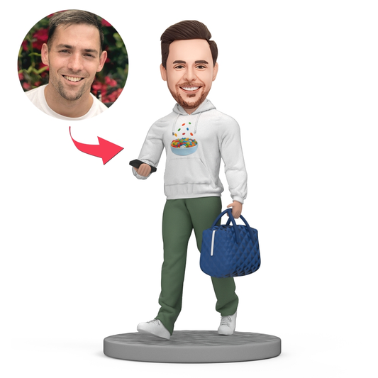 Personalised polymer clay bobblehead of a casual man in a white sweater holding a handbag with a customised head to match your photo, ideal bespoke keepsake gift