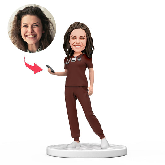 Personalised female doctor bobblehead in red scrubs holding a phone, custom face doll with engraved base – ideal NHS/GP gift, polymer clay figurine