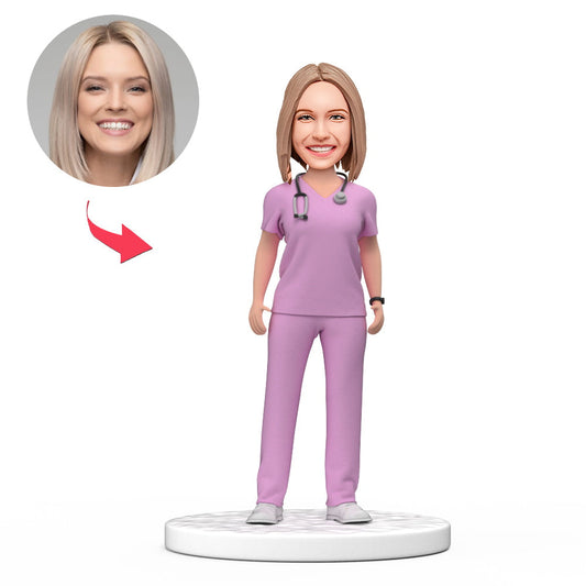 Personalised female doctor bobblehead in purple scrubs with engraved base — handmade polymer clay desk ornament, custom face from photo, ideal NHS/GP graduation gift