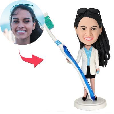 Personalised female dentist custom bobblehead holding a toothbrush, personalised face and engraved base, hand‑sculpted polymer clay gift for dentists (UK & Australia)