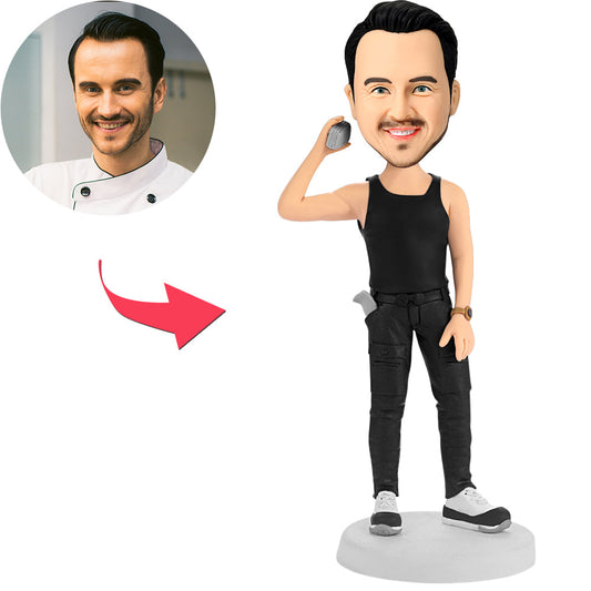 Man holding phone personalised bobblehead with engraved text on base — custom polymer clay figurine, personalised bobblehead gift