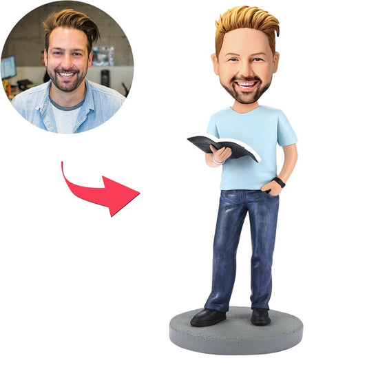 Front view of personalised modern reading book man bobblehead with custom head and engraved text on base, polymer clay book-lover gift