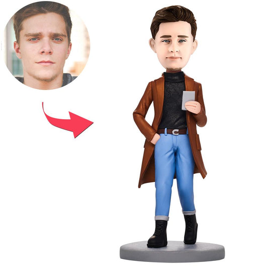Personalised polymer clay bobblehead of a casual man holding a phone — handcrafted custom bobble head with engraved name on the base, ideal engraved bobblehead gift