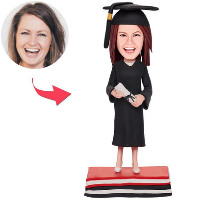 Personalised graduation girl bobblehead in mortarboard and gown — polymer clay bobblehead with engraved base, a bespoke graduation keepsake