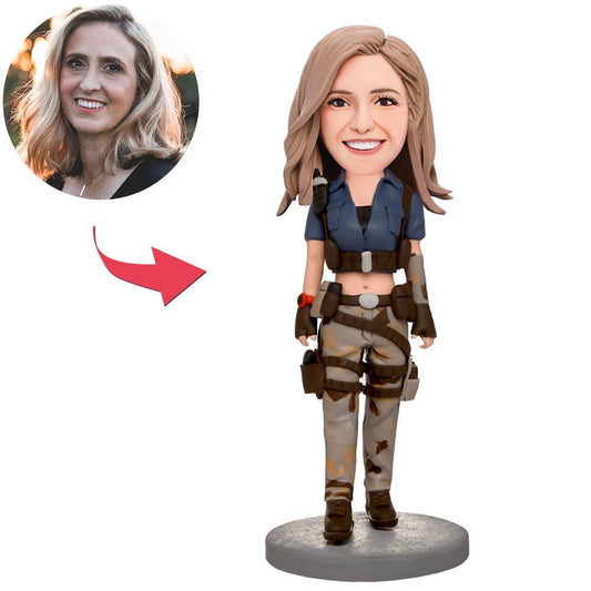 Female holding gun personalised bobblehead — hand-crafted polymer clay figurine with personalised head and engraved text on the base, custom bobblehead gift