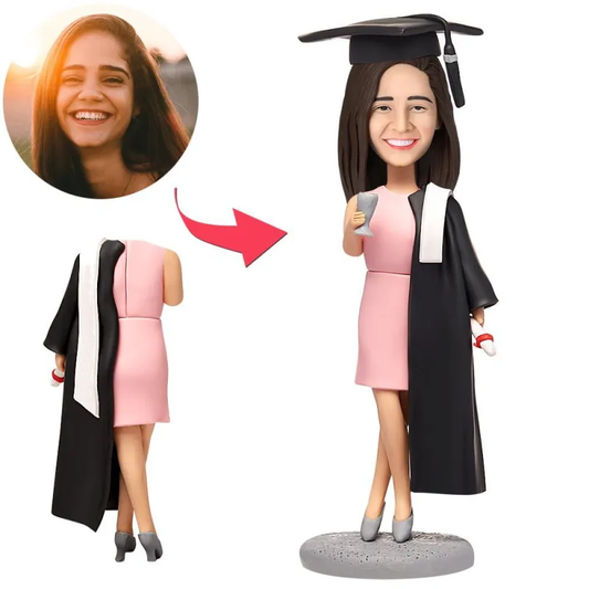 Personalised female graduate bobblehead in skirt wearing mortarboard, polymer clay bobblehead with a custom head from your photo and engraved base for name or message — ideal personalised graduate bobblehead gift.