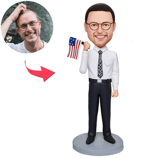 Personalised businessman bobblehead holding an American flag — handmade polymer clay figurine with custom face and engraved base, ideal corporate desk gift