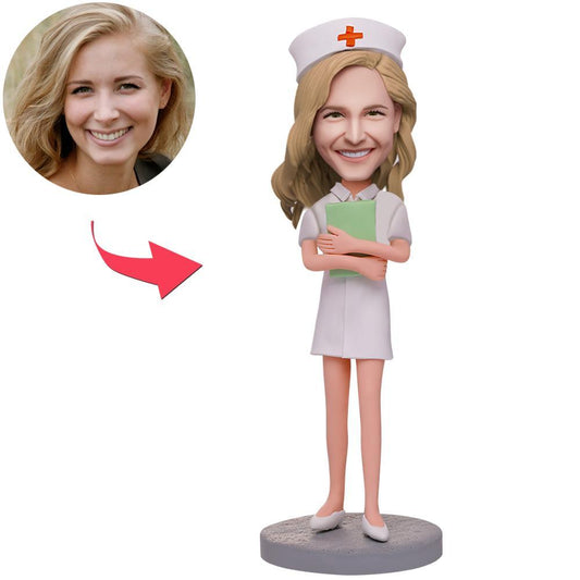 Personalised female nurse bobblehead holding a notebook, handcrafted polymer clay figure with a custom sculpted head from your photo and engraved name on the base — perfect personalised nurse gift and thank you keepsake