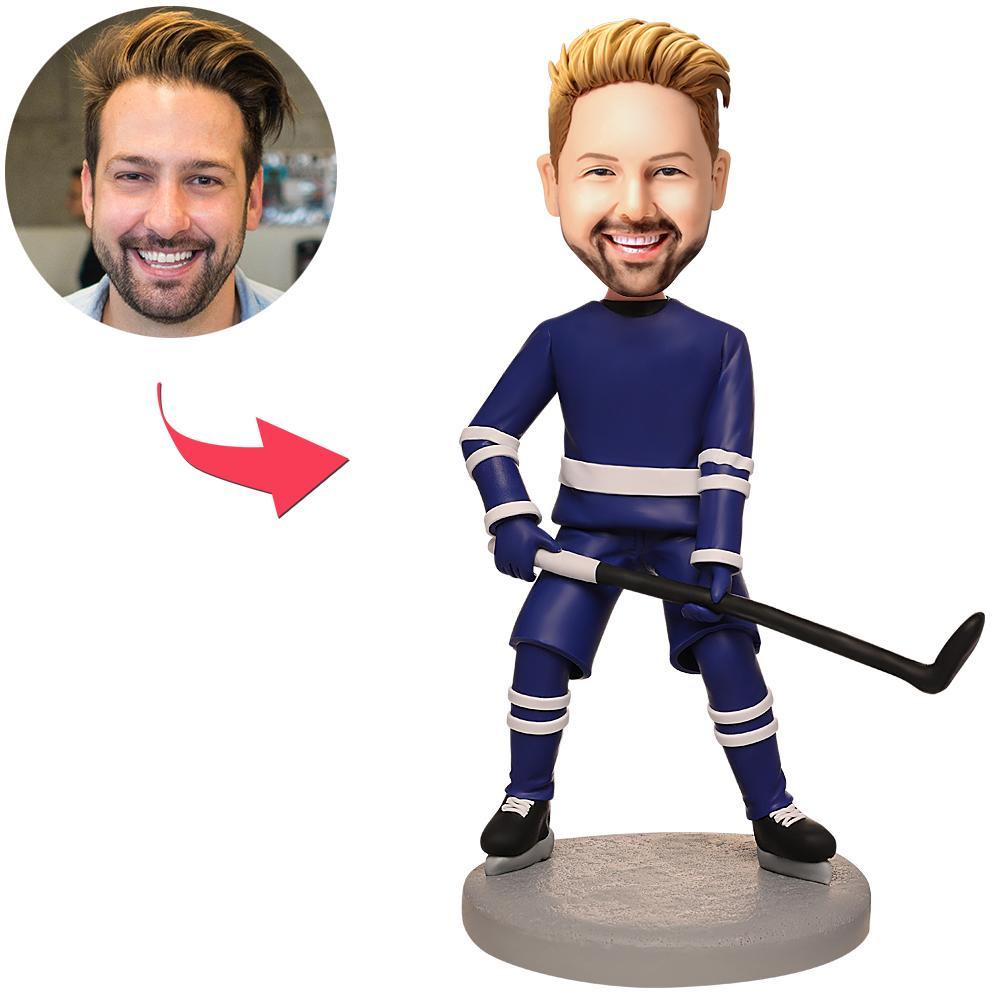 Personalised blue suit hockey player bobblehead with custom head, handcrafted polymer clay figure in blue suit holding a hockey stick on a display base — custom head created from your photo