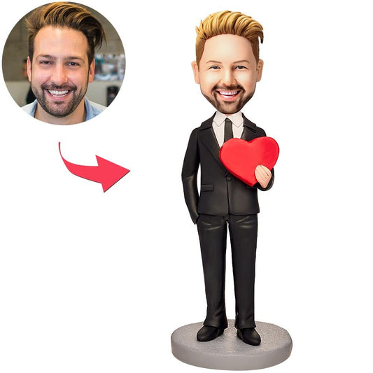 Personalised man holding love heart bobblehead in polymer clay with engraved text on base – custom bobblehead gift for anniversaries, weddings and engagements (UK & Australia)