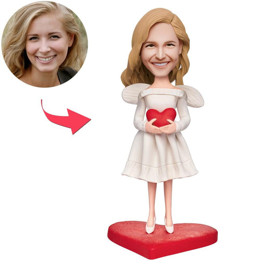 Personalised angel girl bobblehead holding an engraved love heart — polymer clay engraved-heart bobblehead with customised head and personalised text, perfect keepsake gift