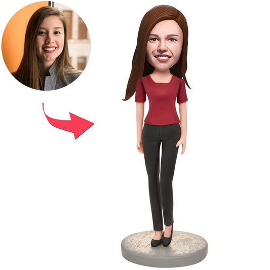 Front view of a personalised woman bobblehead wearing a red T‑shirt, handcrafted from polymer clay with customised head likeness and engraved text on the base — ideal personalised bobblehead gift.