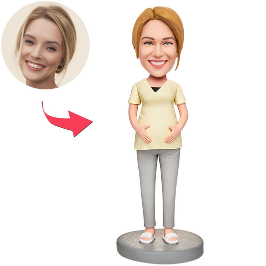 Custom pregnant mother bobblehead, handcrafted polymer clay figure with personalised head and engraved text on base — maternity keepsake for mum-to-be