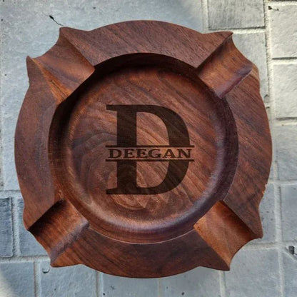 Compact personalised walnut ashtray shown in hand to illustrate size (W12cm x H2.8cm) – engraved wooden cigar rest