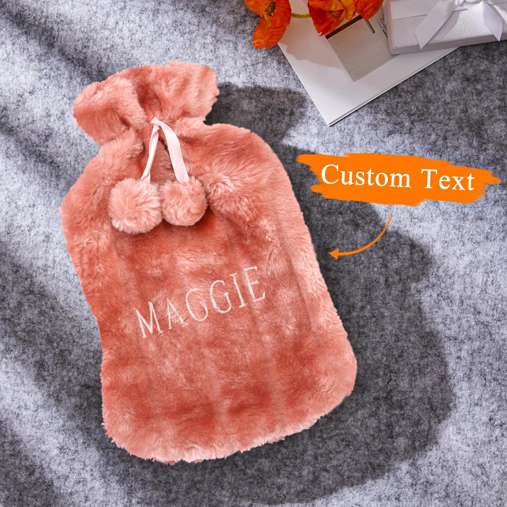 Close-up of plush cover fabric and embroidered lettering on a personalised hot water bottle, showing removable washable cover
