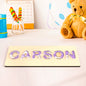 Personalised name puzzle with colourful acrylic letters on a smooth wooden base — custom Montessori baby gift