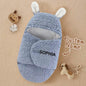 Front view of hooded bunny-ear swaddle on a neutral background.